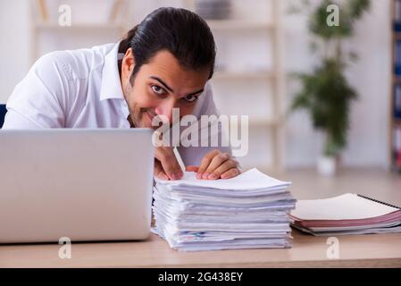 Young businessman employee unhappy with excessive work in the of Stock Photo