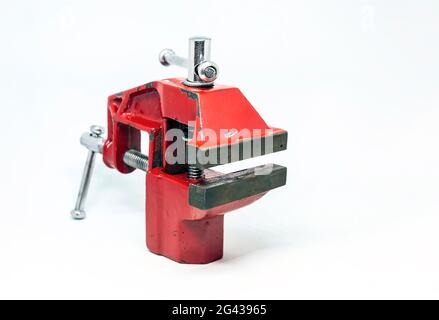 close-up view of a red steel bench vise isolated on a white background. Working tool. Table vise. Stock Photo