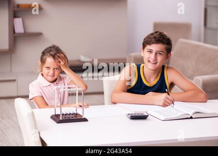 Schoolboy and his small sister staying at home during pandemic Stock Photo