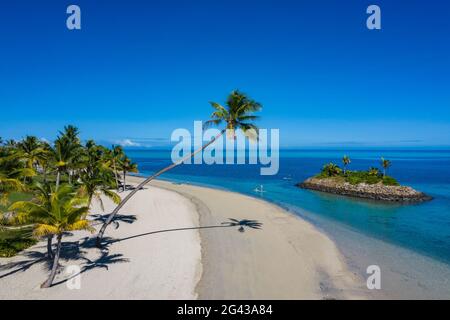 Aerial view of a residence villa accommodation in the Six Senses Fiji Resort with coconut trees, beach and family enjoying water sports activities nex Stock Photo