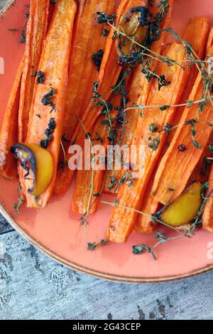 Baked carrots in strips with herbs and spices. Vegan diet. Vegan lunch recipe idea. Stock Photo