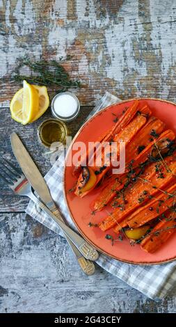 Baked carrots in strips with herbs and spices. Vegan diet. Vegan lunch recipe idea. Stock Photo
