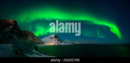 Aurora borealis above Nordlandsnupen mountain and coastline, Vaeroy, Lofoten, Norway Stock Photo