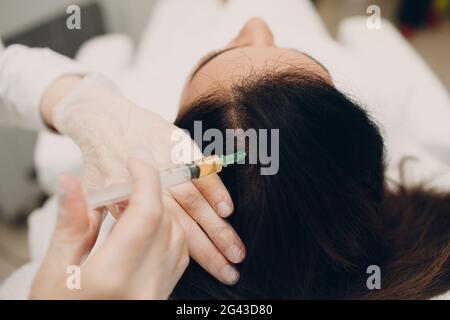 Needle mesotherapy. Cosmetic been injected in woman's head Stock Photo