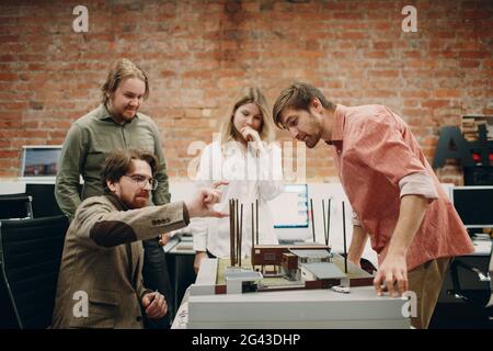 Architects with blueprints and layout building house design project at the office bureau. Stock Photo