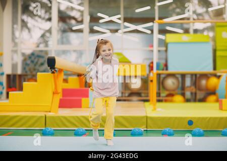 Kids doing exercises with skipping rope in gym at kindergarten or elementary school. Children sport and fitness concept. Stock Photo