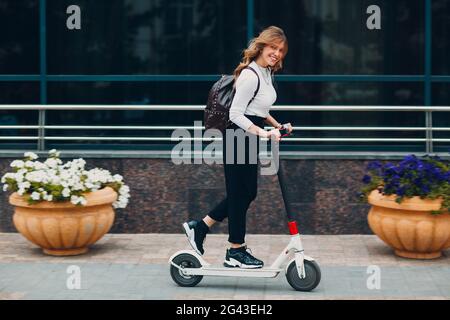 Young woman driving electric scooter at the city Stock Photo