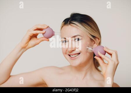 Cupping therapy and spa procedure, woman with little medical cup for face Stock Photo