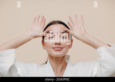 Young woman doing face building facial gymnastics self massage and rejuvenating exercises Stock Photo