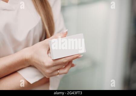 Female hand holding white blank box package Stock Photo