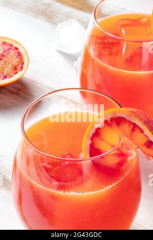 Orange cocktail close-up with blood oranges on a wooden table Stock Photo