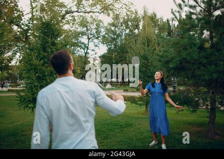 Young adult couple playing badminton in the park Stock Photo