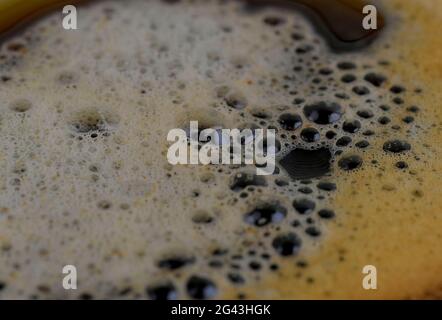 Coffee surface texture. Foam bubbles in detail. Coffee foam close-up, macro. Abstract background. Black coffee foam texture. Stock Photo