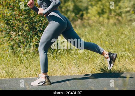 Runner woman in running shoes closeup of woman sporty legs. Female jogging. Stock Photo