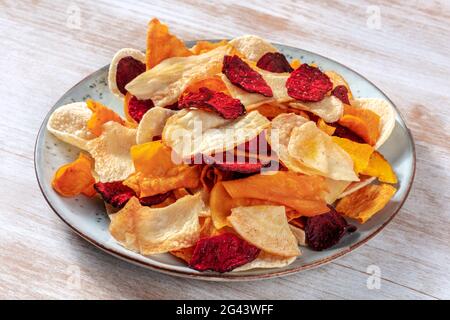 Vegetable chips on a plate, a healthy vegan snack Stock Photo