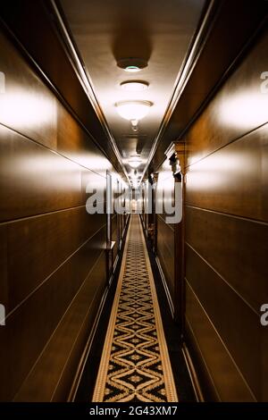 Kotor, Montenegro - 21 MAY 2018: Dark hotel corridor. A long carpet with a pattern, wooden wall cladding. Deserted hotel corrido Stock Photo