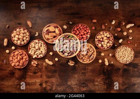 Various nuts, overhead flat lay shot on a wooden background Stock Photo