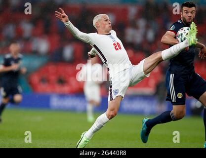 London, UK. 18th June, 2021. England's Phil Foden (L) vies with Scotland's Grant Hanley during the Group D match between England and Scotland at the UEFA Euro 2020 in London, UK, June 18, 2021. Credit: Han Yan/Xinhua/Alamy Live News Stock Photo