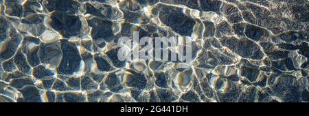 Pebble water caustics background with color refractions Stock Photo