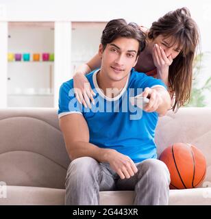 Man watching basketball with his wife Stock Photo - Alamy