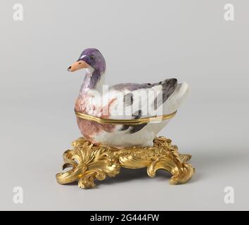 Lid of box in the shape of a duck. Lid of box of painted porcelain, cup and back of a duck. The duck is partially painted in blue, brown, gray, violet and black; The head in violet and blue gray with a light red beak. Stock Photo