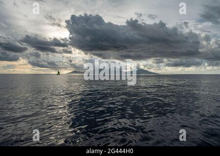 Clouds over the island of Moorea just before sunset, near Papeete, Tahiti, Windward Islands, French Polynesia, South Pacific Stock Photo
