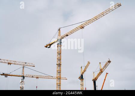 Yellow cranes against the blue sky. Construction background. Stock Photo