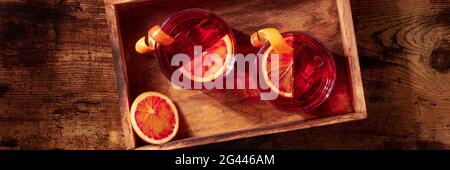 Negroni cocktail with blood oranges panorama on a wooden background Stock Photo