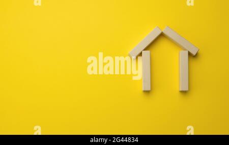 Wooden miniature house on a yellow background. The concept of buying and selling a house, renting and leasing real estate Stock Photo