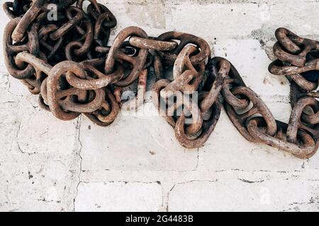 Old rusty chain on a stone background. Several links of a rusty old chain Stock Photo
