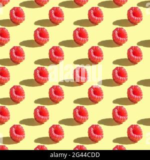 Seamless pattern of raspberries on a yellow background with clear shadows. Stock Photo