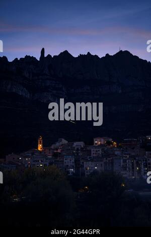 Blue hour - twilight on the mountain of Montserrat, with the town of Monistrol de Montserrat in the foreground (Bages, Barcelona, Catalonia, Spain) Stock Photo