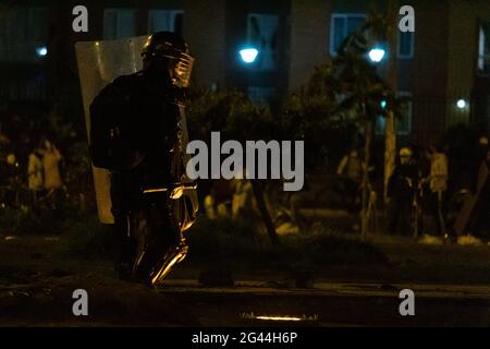 Bogota, Colombia. 17th June, 2021. A Colombia's riot police officer (ESMAD) is lit by a floor light as cultural acts and demonstrations escalated later in the night to clashes betweem demonstrators and Colombia's riot police (ESMAD) admist anti-government protest against president Ivan Duque, on June 17, 2021 in Bogota, Colombia. Credit: Long Visual Press/Alamy Live News Stock Photo