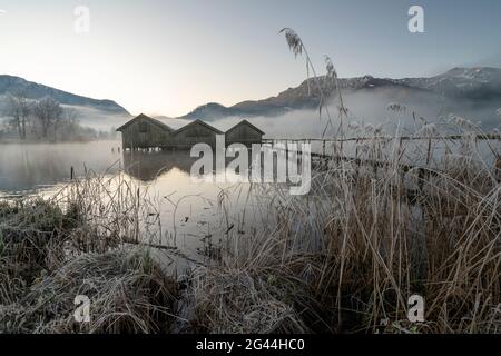 Three fishing huts on the Kochelsee in the morning light near Schlehdorf, Bavaria, Germany. Stock Photo