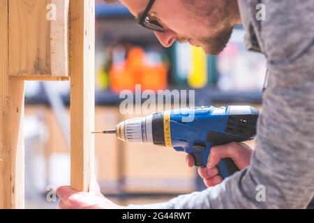 Do it yourself: Home Handyman is using a cordless screwdriver for screwing Stock Photo
