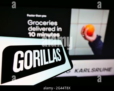 Cellphone with logo of German delivery company Gorillas Technologies GmbH on screen in front of website. Focus on center-right of phone display. Stock Photo