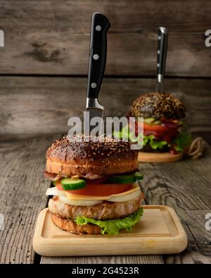 Cheeseburger with bun, meat and vegetables on a wooden background Stock Photo