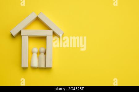 Wooden miniature house on a yellow background. The concept of buying and selling a house, renting and leasing real estate, insur Stock Photo