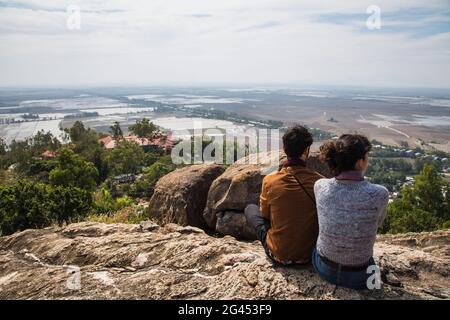 Couple looks out over rice fields near Vietnam and Cambodia border from Long Son Pagoda on Sam Mountain, near Chau Doc, An Giang, Vietnam, Asia Stock Photo