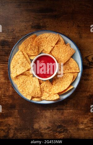 Nacho chips with a tomato salsa, served on a plate Stock Photo