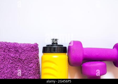 Fitness gym equipment. Dumbbells with towel and wate bottler. Workout footwear. Sport trainers on white background. sport, healthy lifestyle and objec Stock Photo