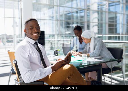 Happy Businessman using digital tablet at desk in office Stock Photo