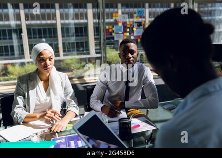 Male and female executives working together on computer at desk Stock Photo