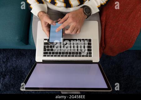Man using a smartphone and laptop Stock Photo