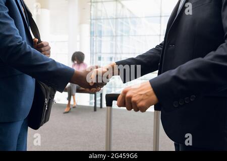 Travelling businessmen shaking hands Stock Photo