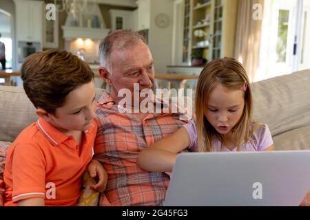 Grandfather and grandchildren at home in the living room Stock Photo