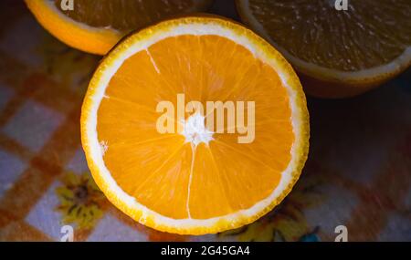 Close up of an orange sliced in half and placed on a plastic cutting board. Stock Photo