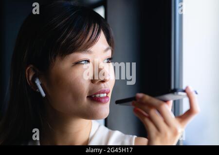 Asian woman having a phone call and looking outside Stock Photo