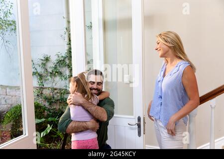 Caucasian man and his daughter embracing in the hallway Stock Photo