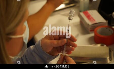 Los Angeles, USA. 18th June, 2021. A medical worker prepares a dose of COVID-19 vaccine at the Universal Studios Hollywood in Los Angeles, California, the United States, June 18, 2021. California has launched a digital platform through which local residents could get access to their COVID-19 vaccine records. Credit: Zeng Hui/Xinhua/Alamy Live News Stock Photo